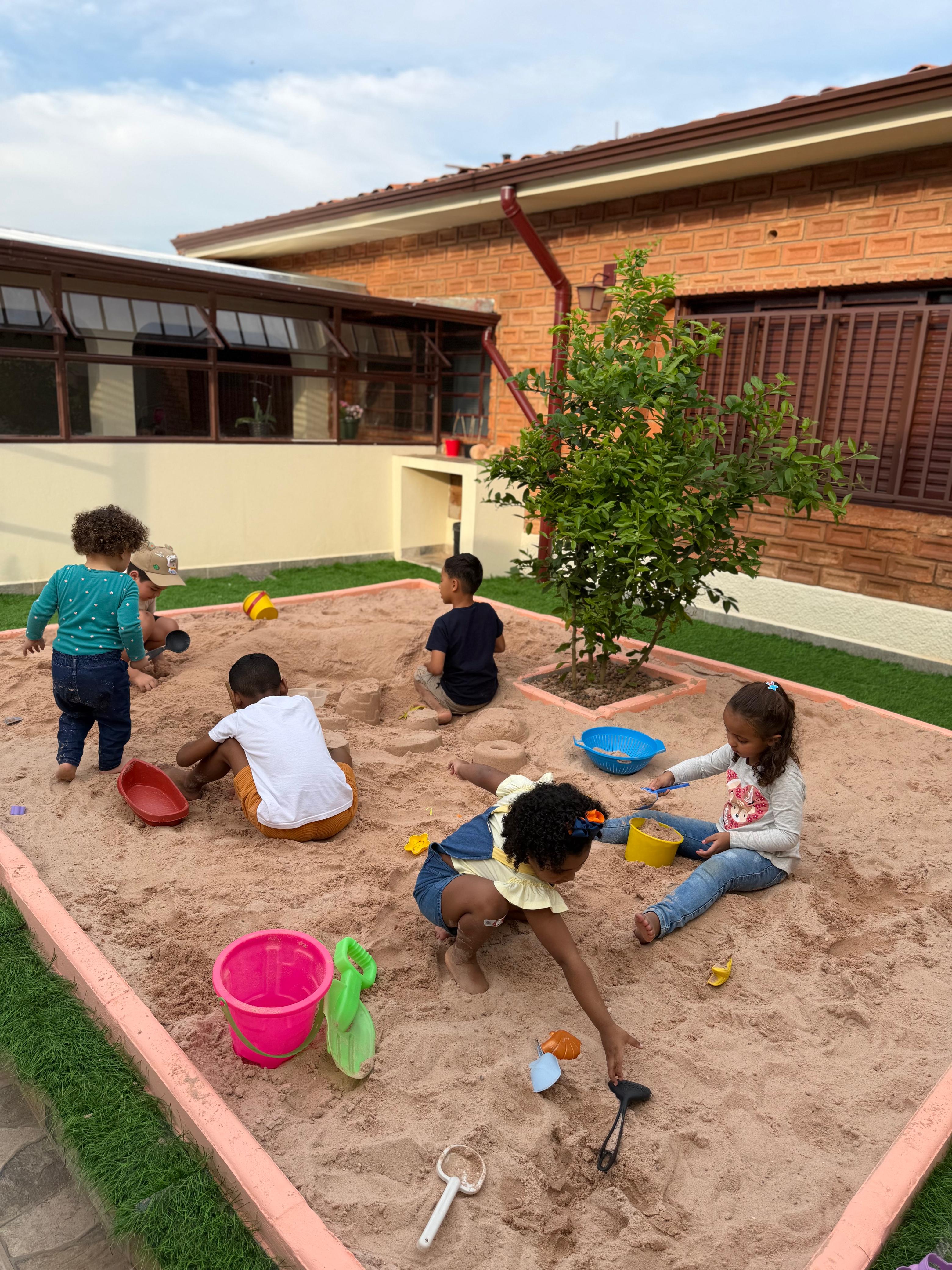 Crianças brincando no quintal de areia do Vila Baobá em Campinas