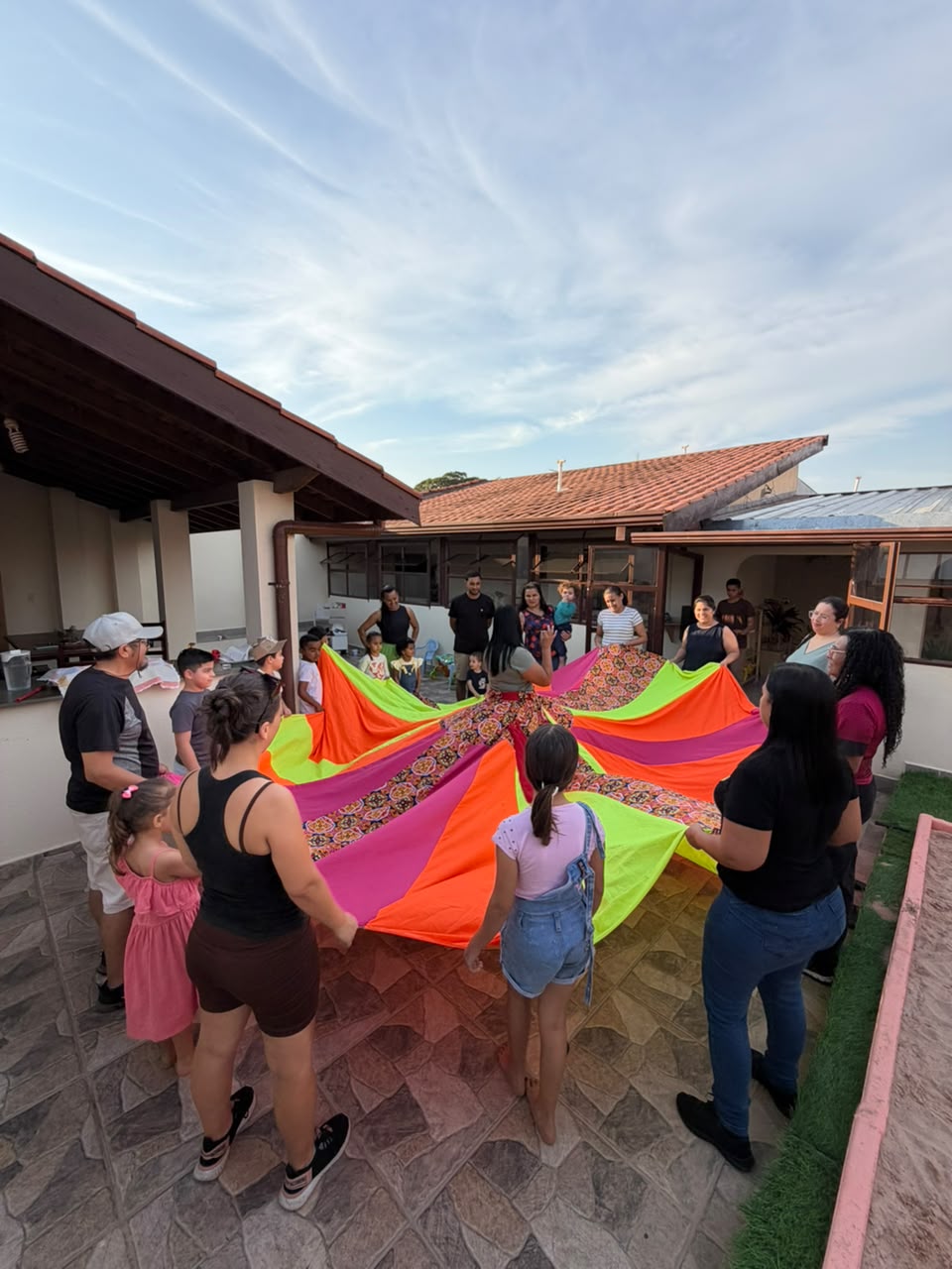 Crianças, famílias e equipe do Vila Baobá em uma experiência coletiva no quintal